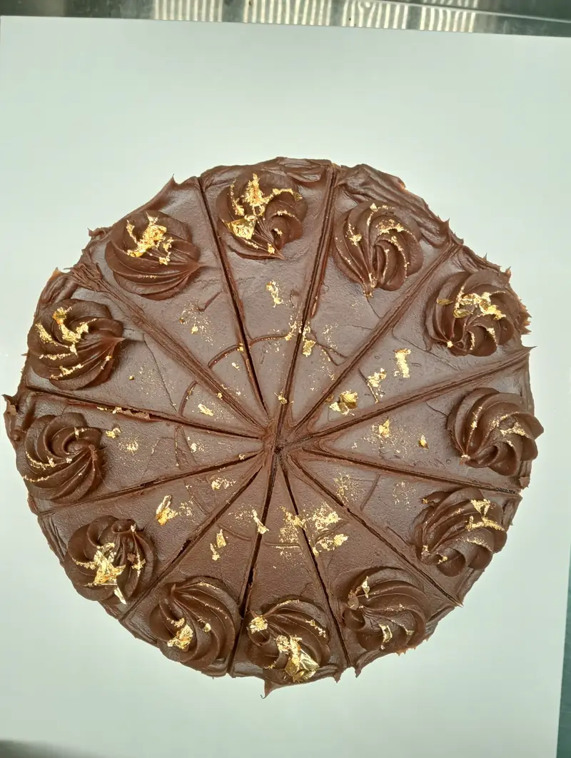 Cheesecake de chocolate con detalles dorados marcado en porciones
