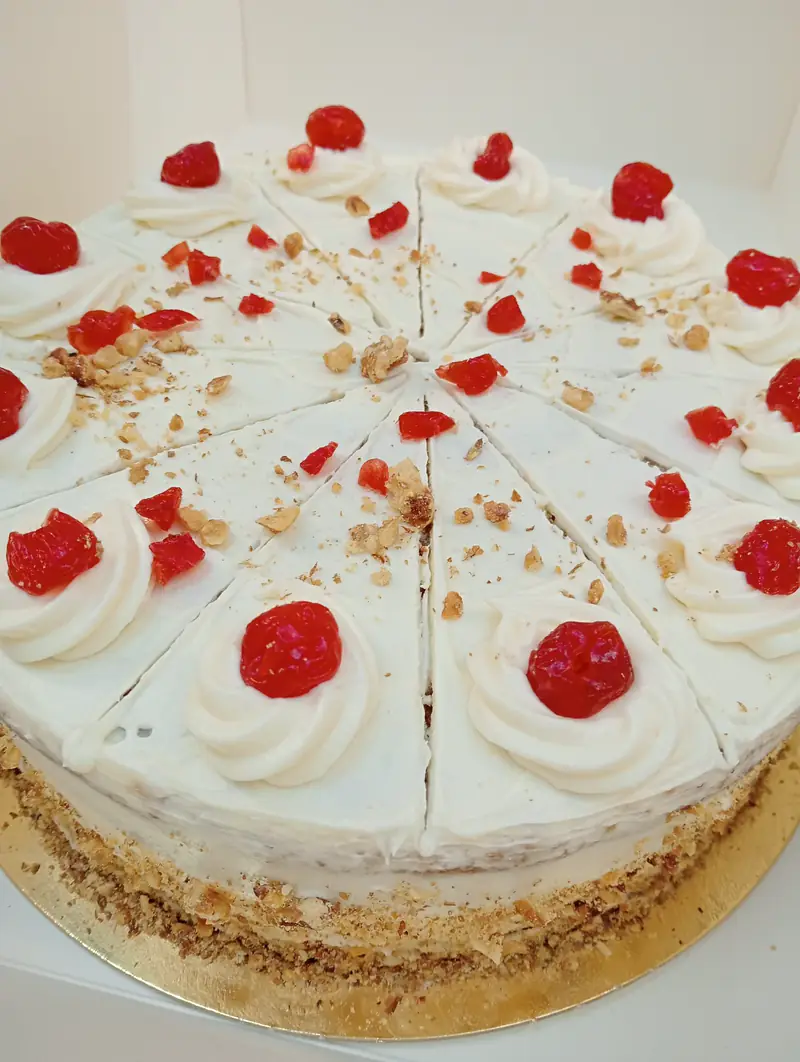 Cheesecake de crema blanca con decoración roja marcado en porciones