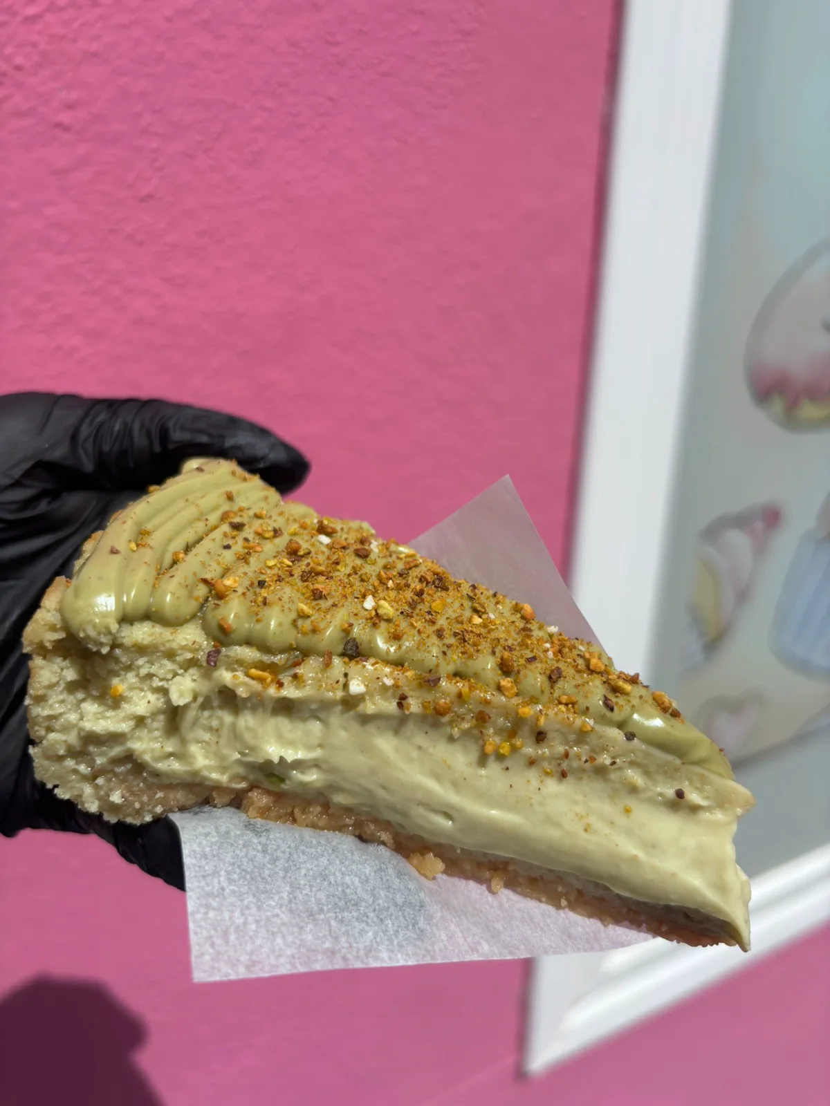 Porción de cheesecake de pistacho preparada en el obrador