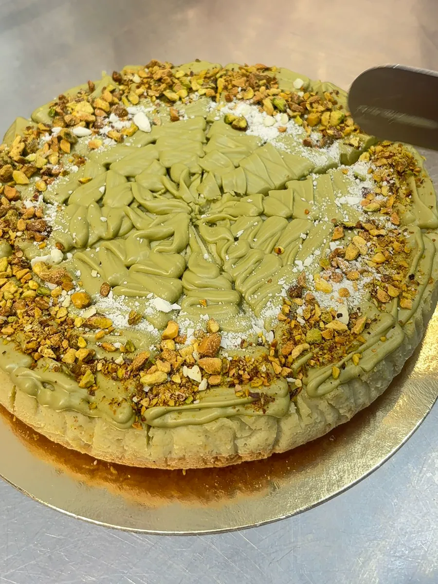 Cheesecake artesanal de pistacho marcado en porciones para una cafetería