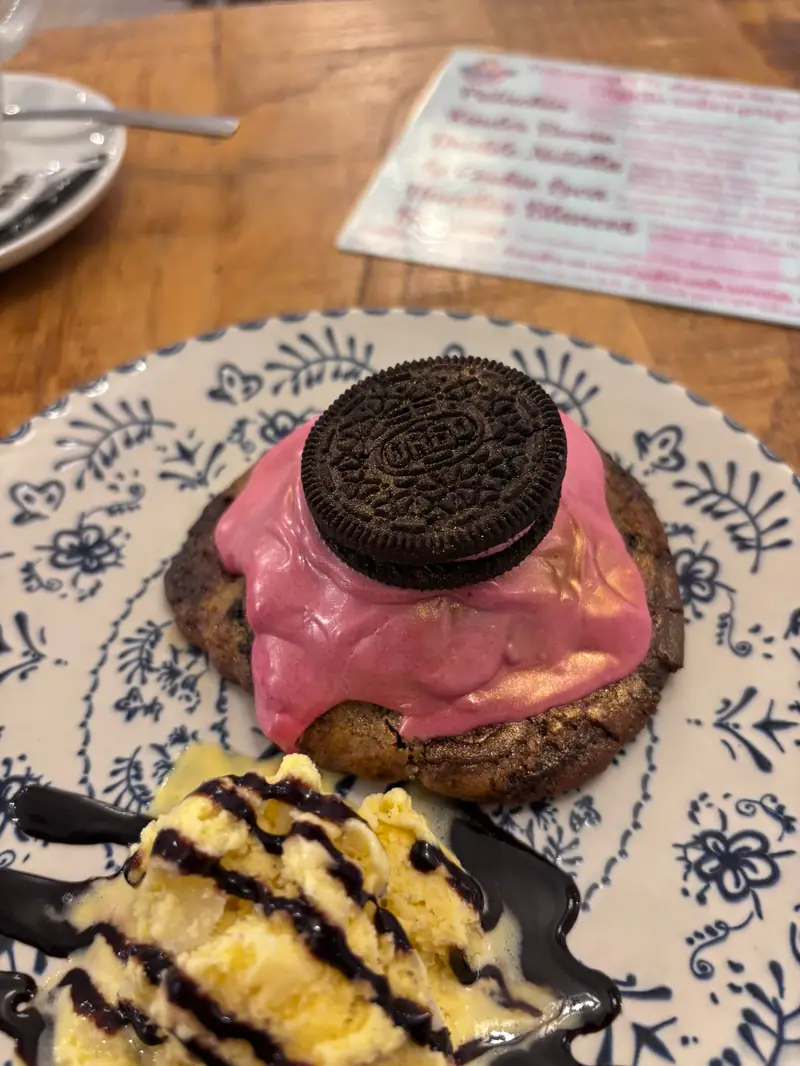 Cookie con crema rosa y Oreo servida con helado y salsa de chocolate