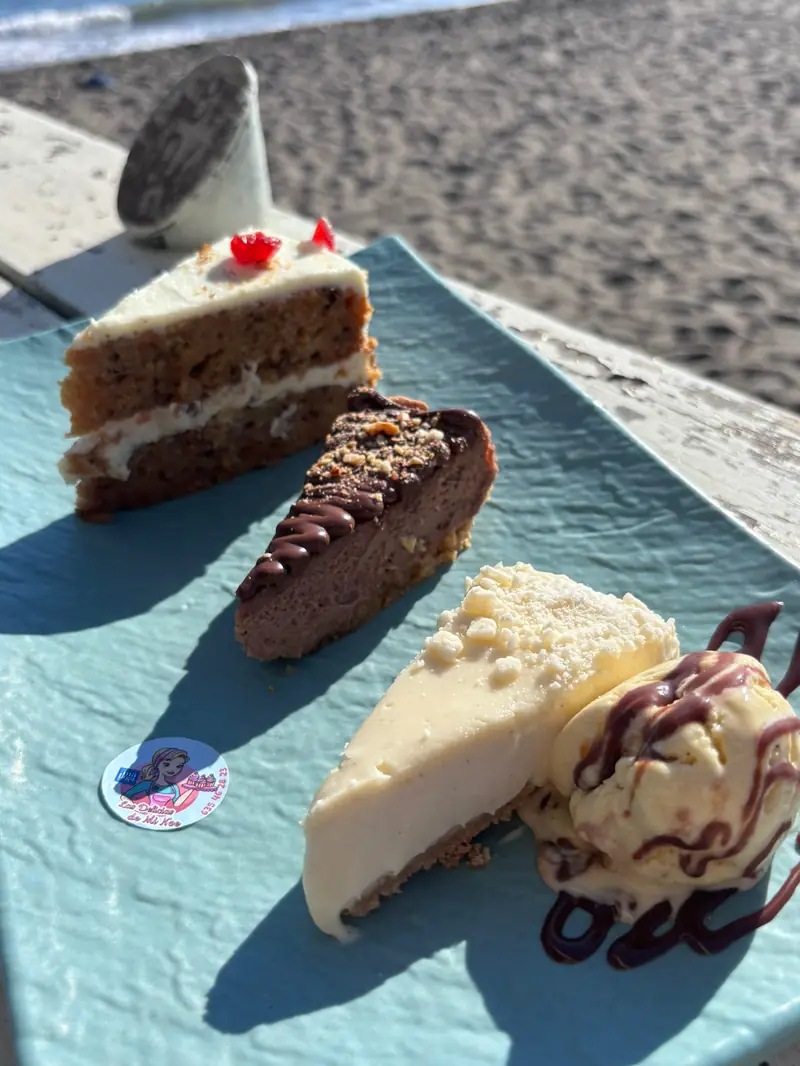 Porciones de varios cheesecakes servidas con una bola de helado en un chiringuito