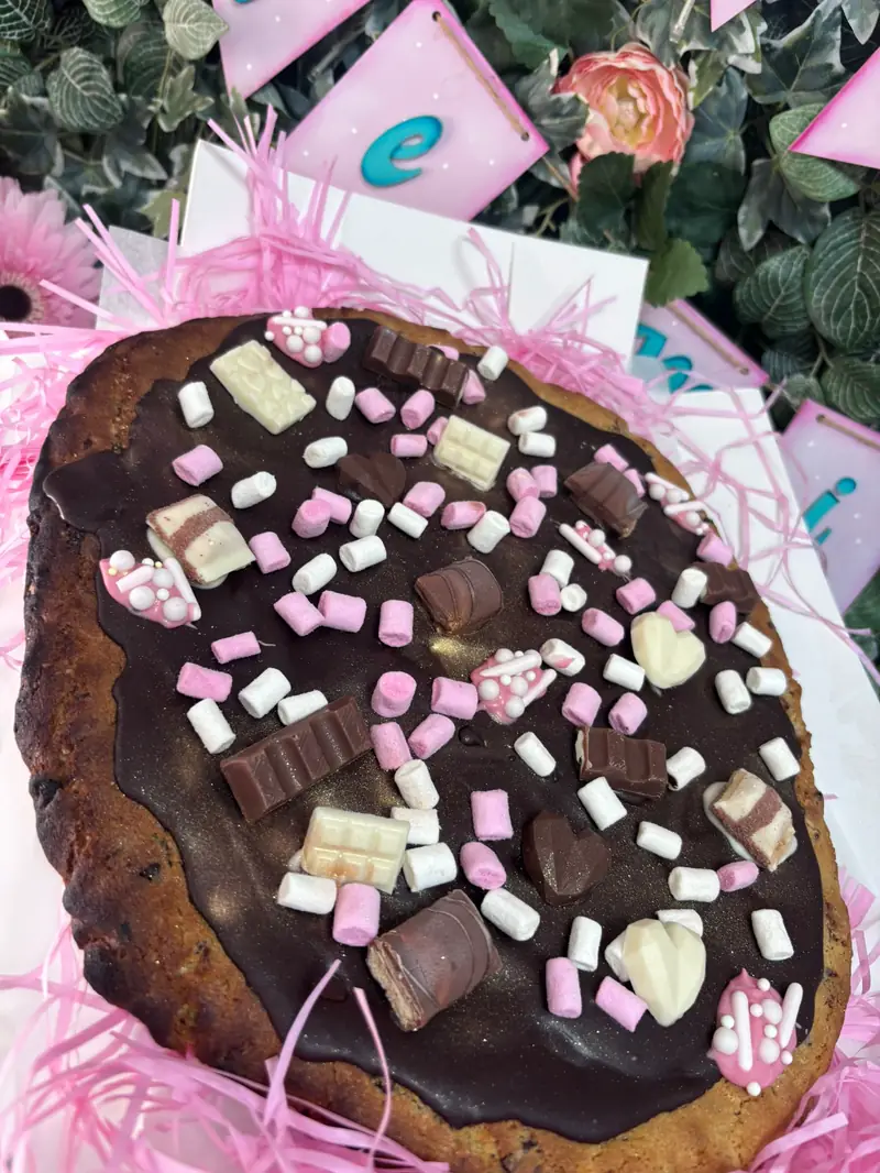 Super cookie personalizada cubierta de chocolate, chocolatinas y mini nubes rosas y blancas