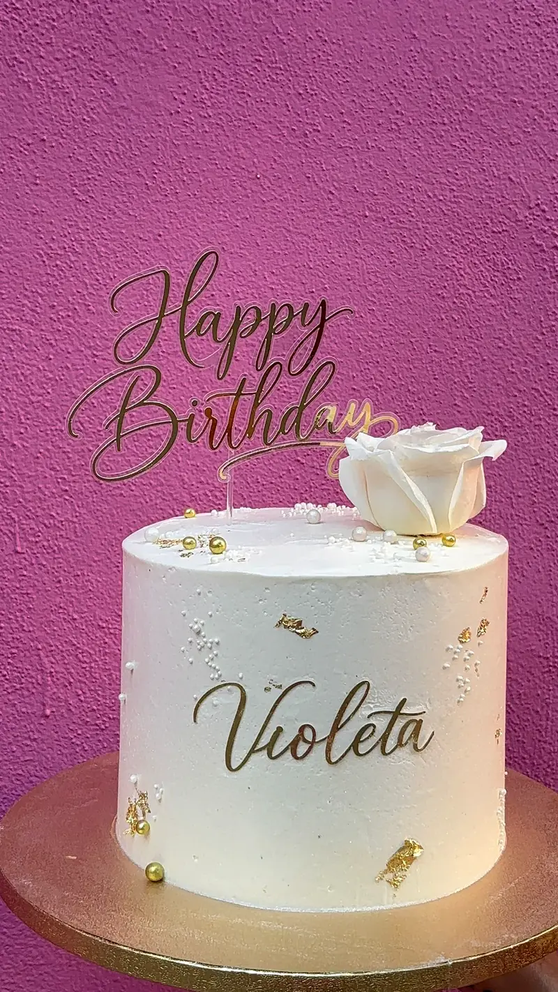 Tarta de cumpleaños blanca personalizada con el nombre Violeta y detalles dorados