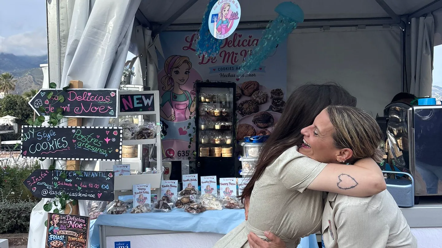 Noelia Lara abrazando a una visitante delante de su puesto de Las Delicias de Mi Noe